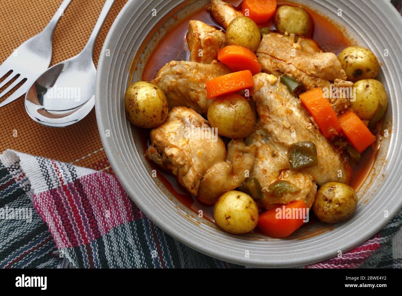 Photo of freshly cooked Filipino food Chicken Afritada or chicken cooked in tomato sauce with potatoes and carrots. Stock Photo