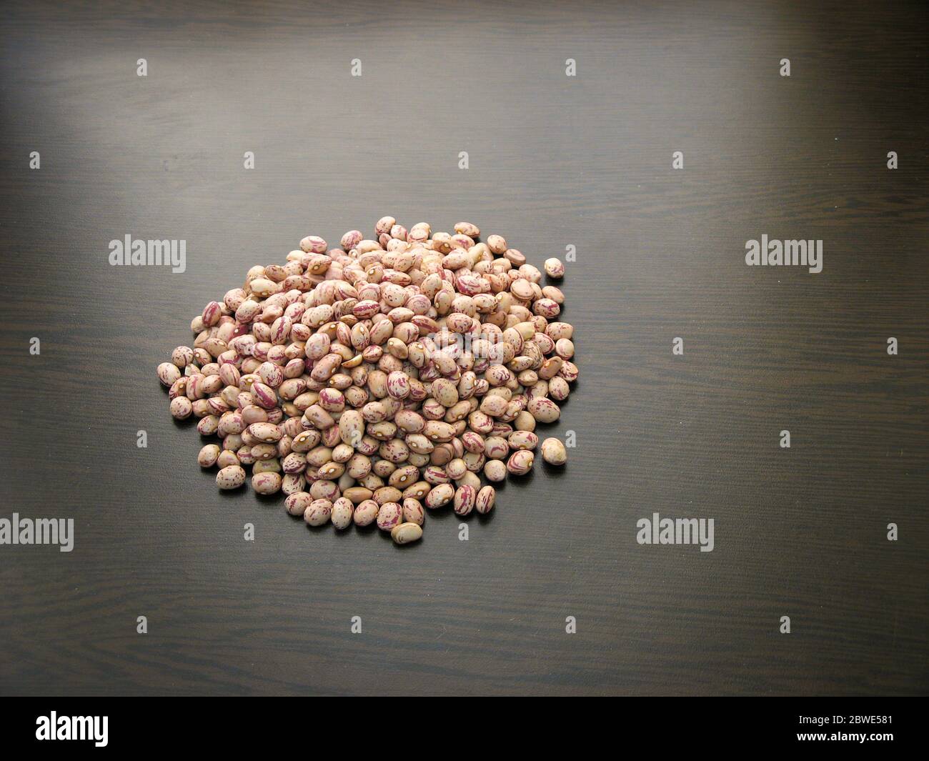 Pinto bean heap on dark background.Dried roman beans or dried pinto beans on wooden table. Raw