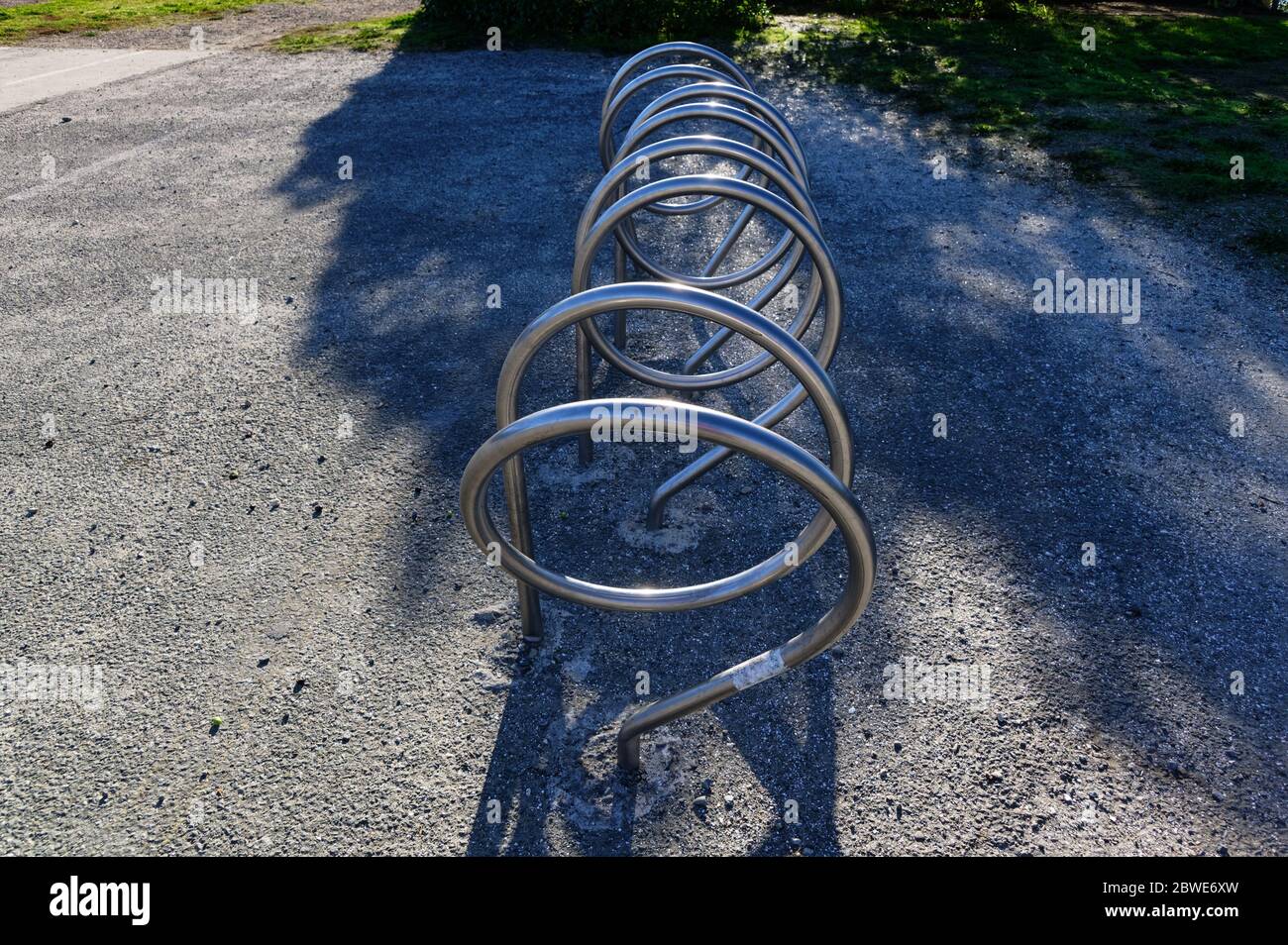 A bicycle rack or bike stand which is stylishly curved in silver metal Stock Photo
