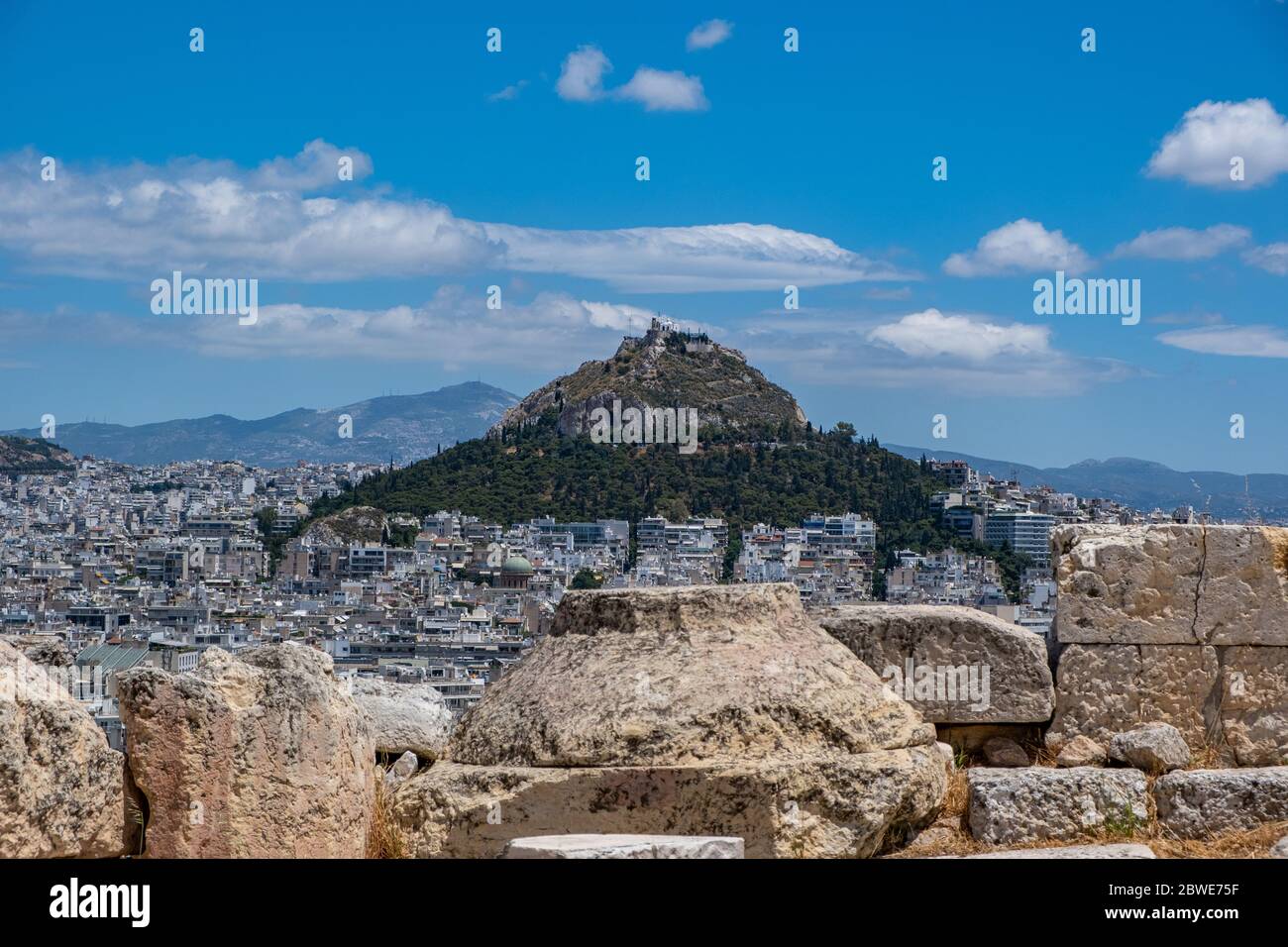 Mount Lycabettus and Athens cityscape aerial photo,  view from Acropolis hill in Greece. Blue sky with clouds, sunny spring day. Stock Photo