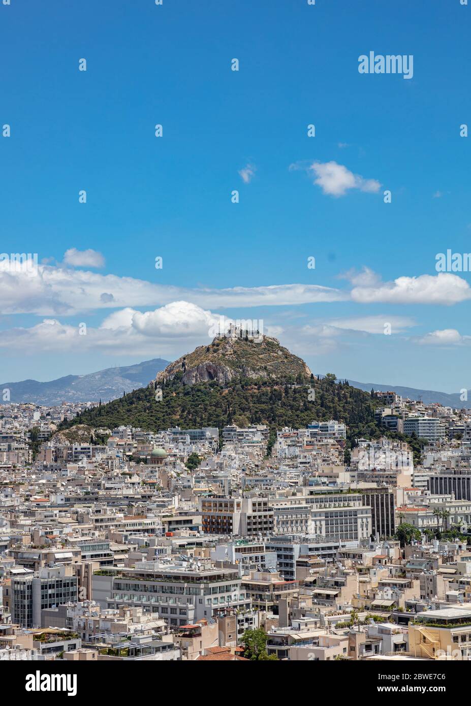 Mount Lycabettus and Athens cityscape aerial photo,  view from Acropolis hill in Greece. Blue sky with clouds, sunny spring day. Stock Photo