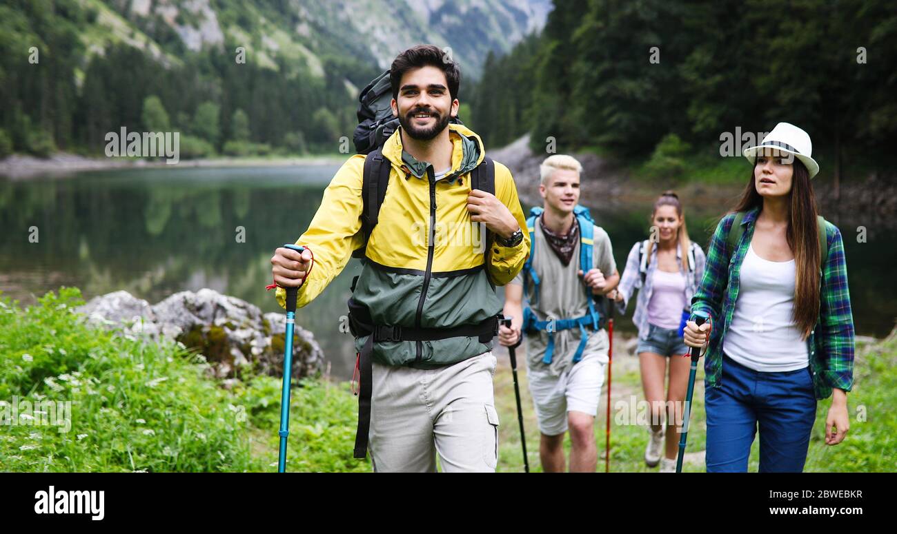 Group of happy friends with backpacks hiking together Stock Photo - Alamy