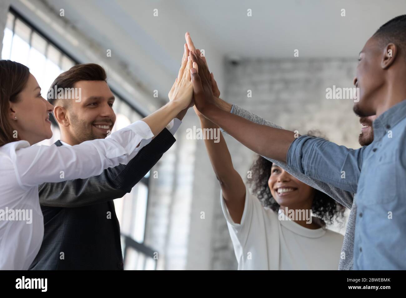 Close up happy successful diverse employees team giving high five Stock ...