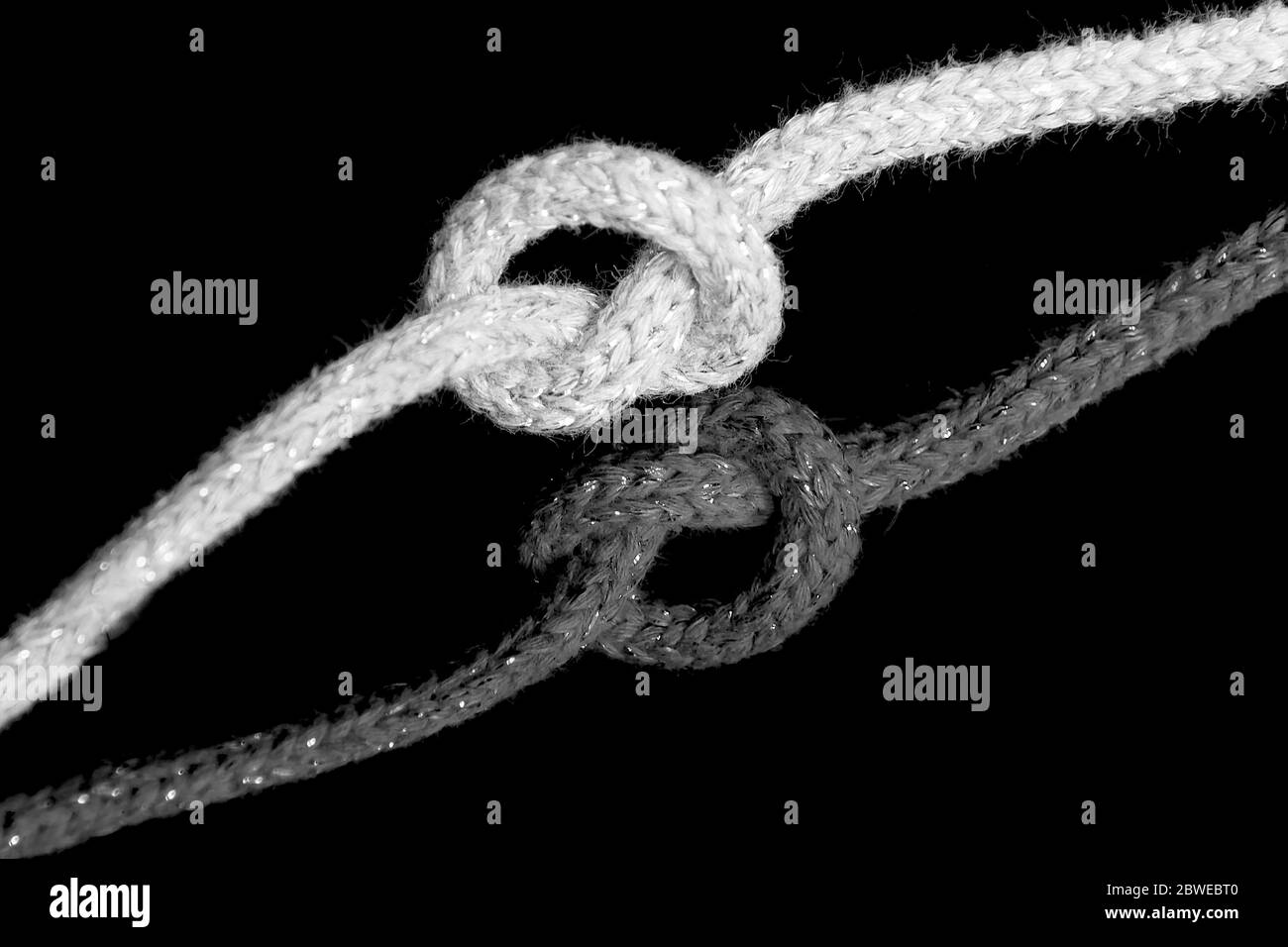 Rope knot and its reflection on black background Stock Photo