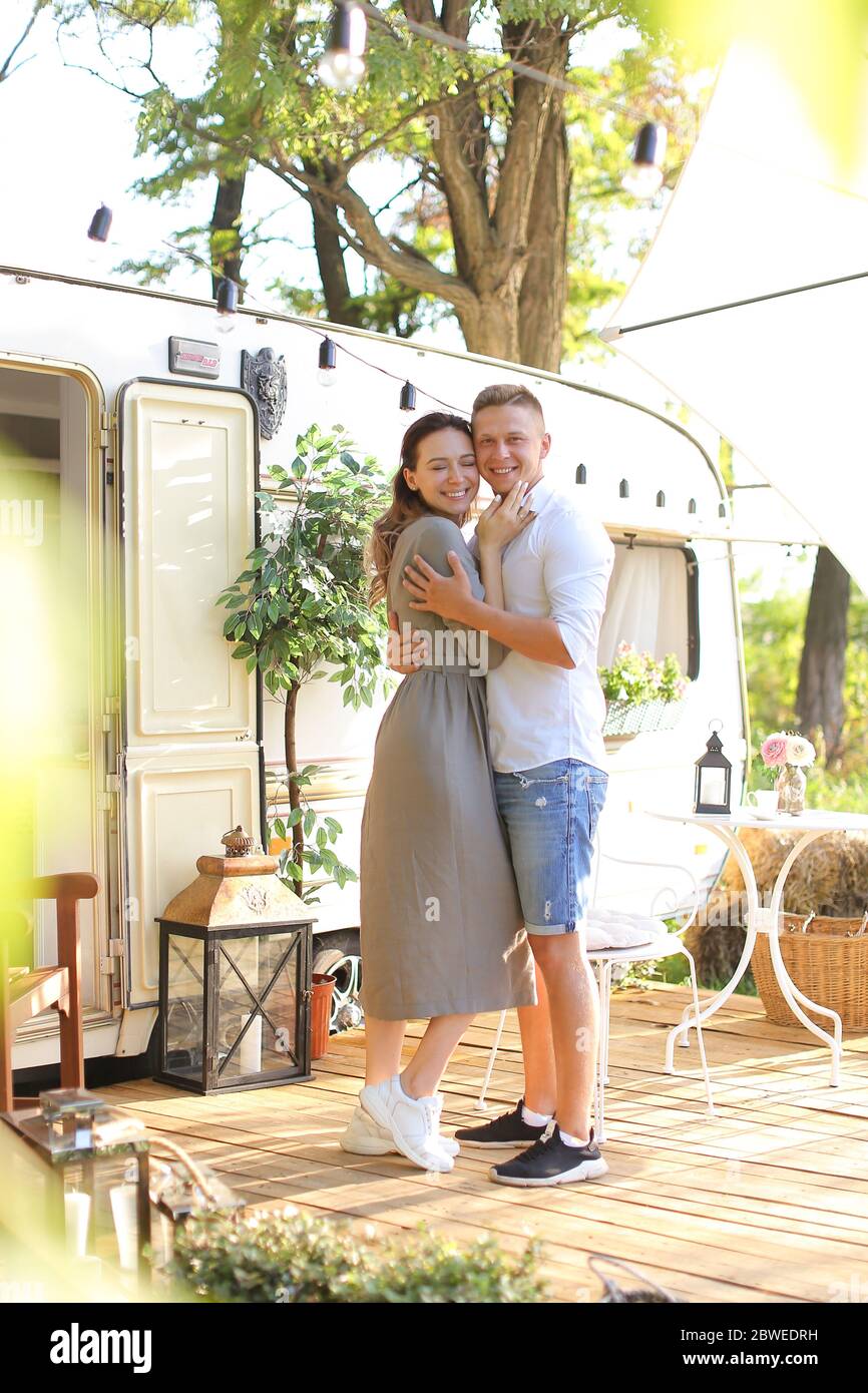 Young wife hugging husband near house on wheels. Stock Photo
