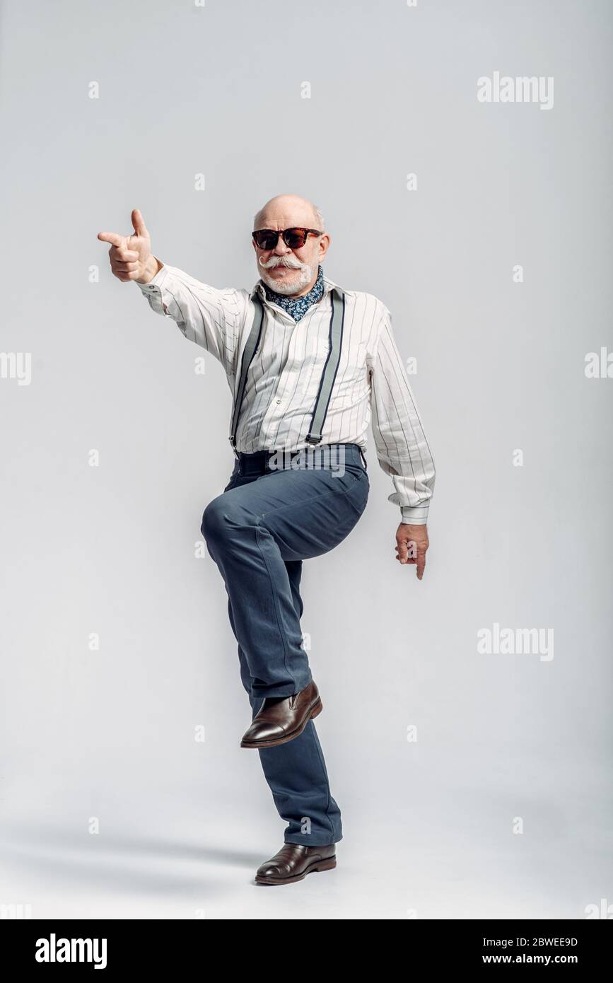Fashionable elderly man makes fingers like a gun Stock Photo