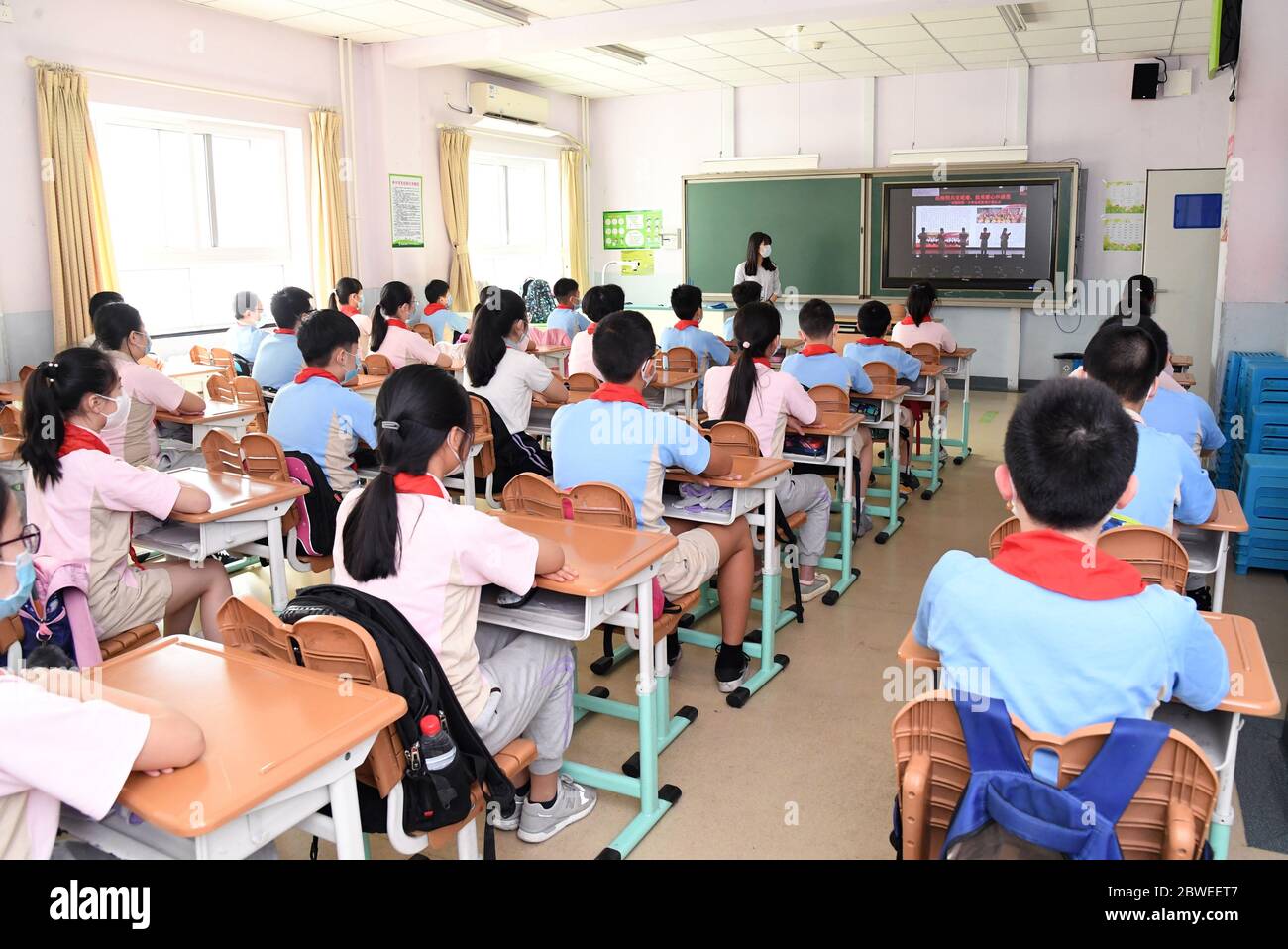 Beijing, China. 1st June, 2020. Students watch a video named the first class of this semester at a classroom in Shuangyushu No. 1 Primary School in Beijing, capital of China, June 1, 2020. Students at their first and second grades of senior high schools, first and second grades of junior high schools and sixth grade of primary schools returned to school for this semester in Beijing on Monday. Credit: Ren Chao/Xinhua/Alamy Live News Stock Photo