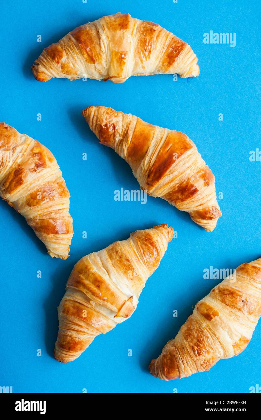 Group of croissants freshly baked on a blue background. Top view. Stock Photo