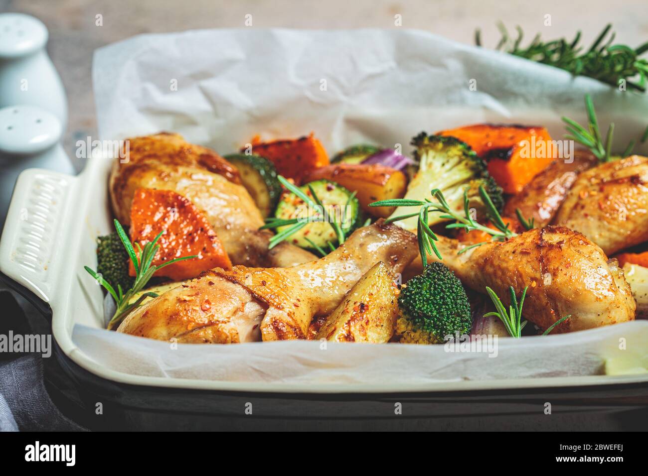 Baked chicken legs with vegetables in the oven dish. Baked chicken with