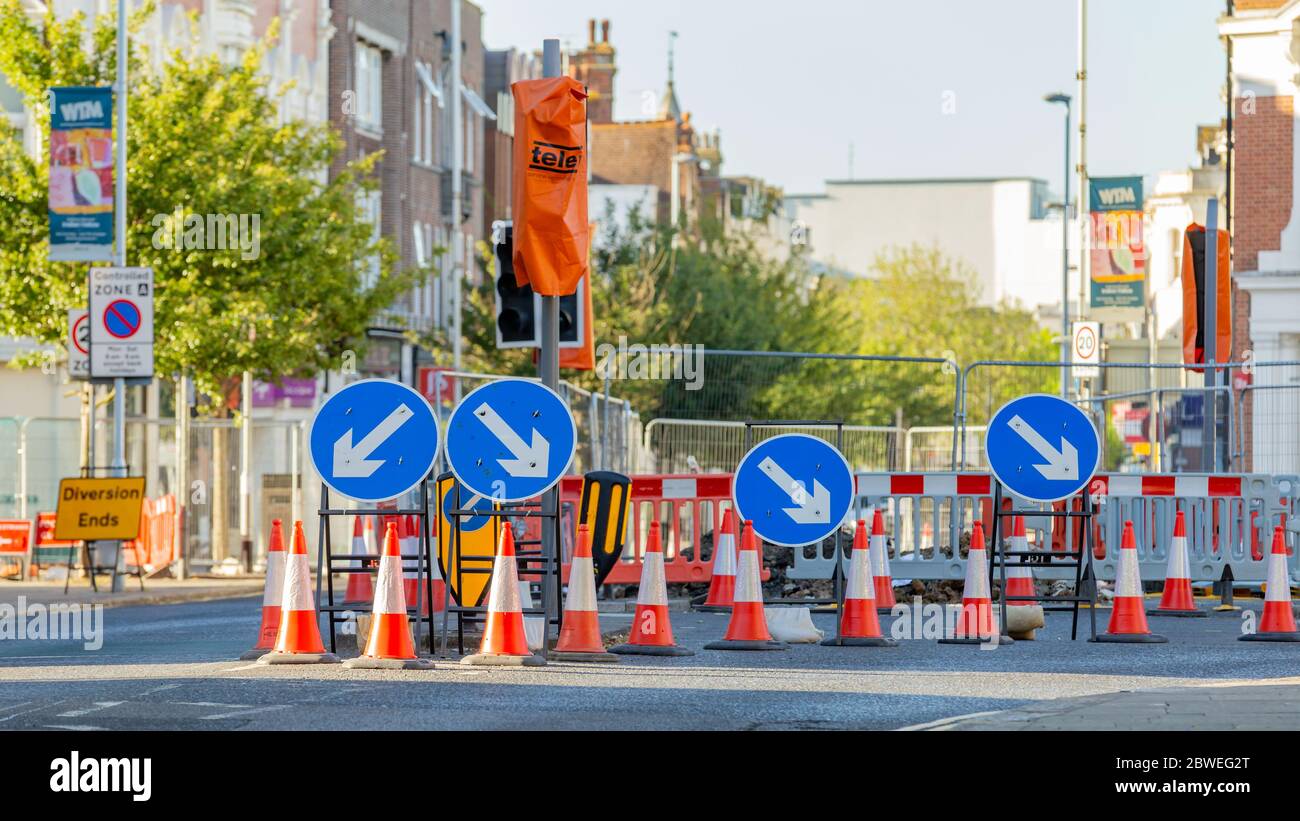 Worthing, Sussex, UK; 29th May 2020; Four Round Blue Road Signs Containing White Arrow Indicating a Mandatory Directional Instruction to Motorists. Stock Photo