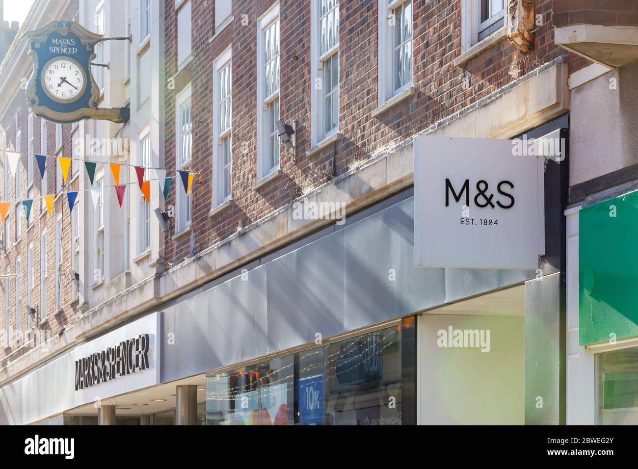 Worthing, Sussex, UK; 29th May 2020; Facade of Marks & Spencers Store at an Oblique Angle With Signage and a Large Clock Visible. Stock Photo