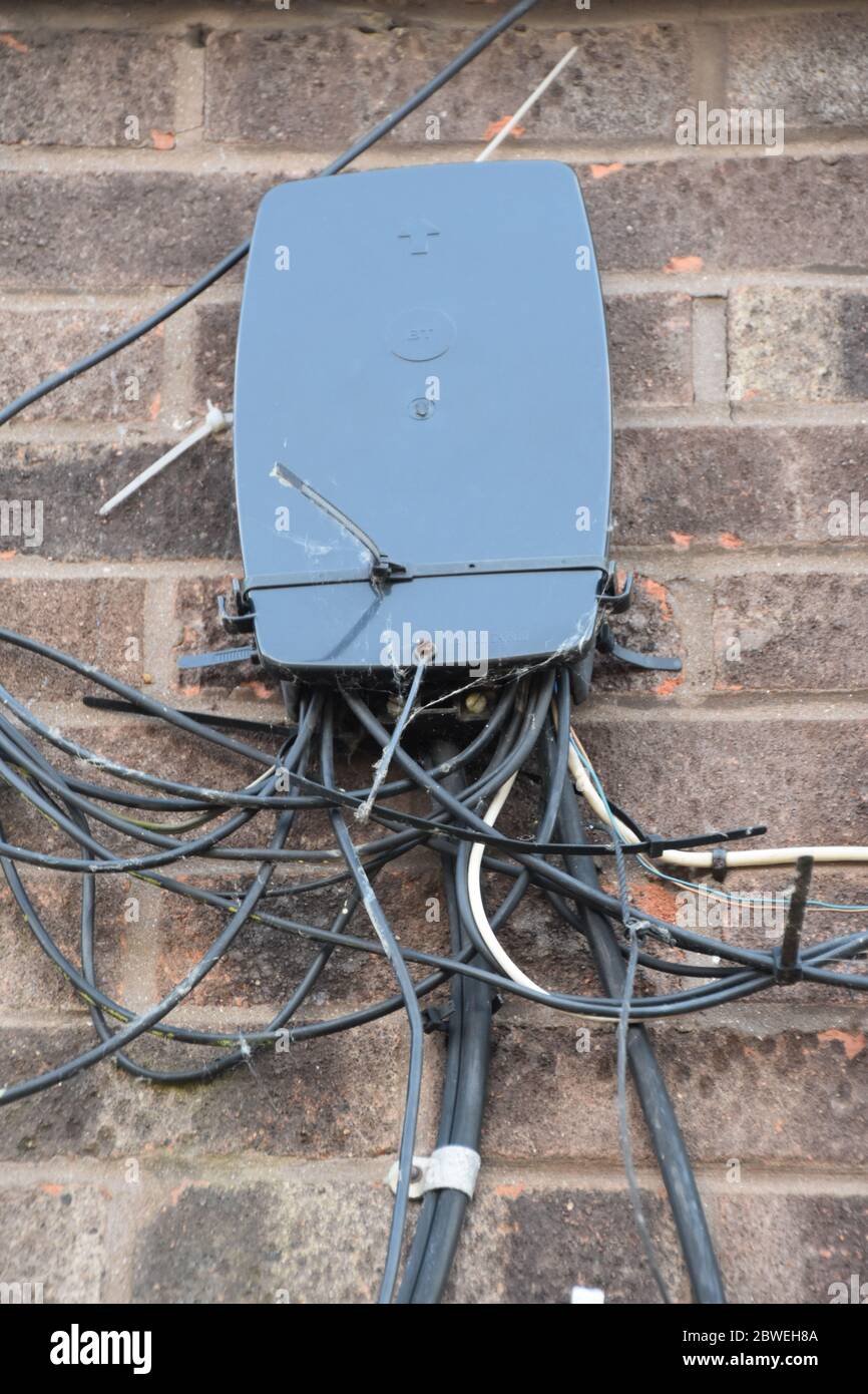 A BT distribution point / DP on a wall with wires going in and out of the British Telecom box Stock Photo