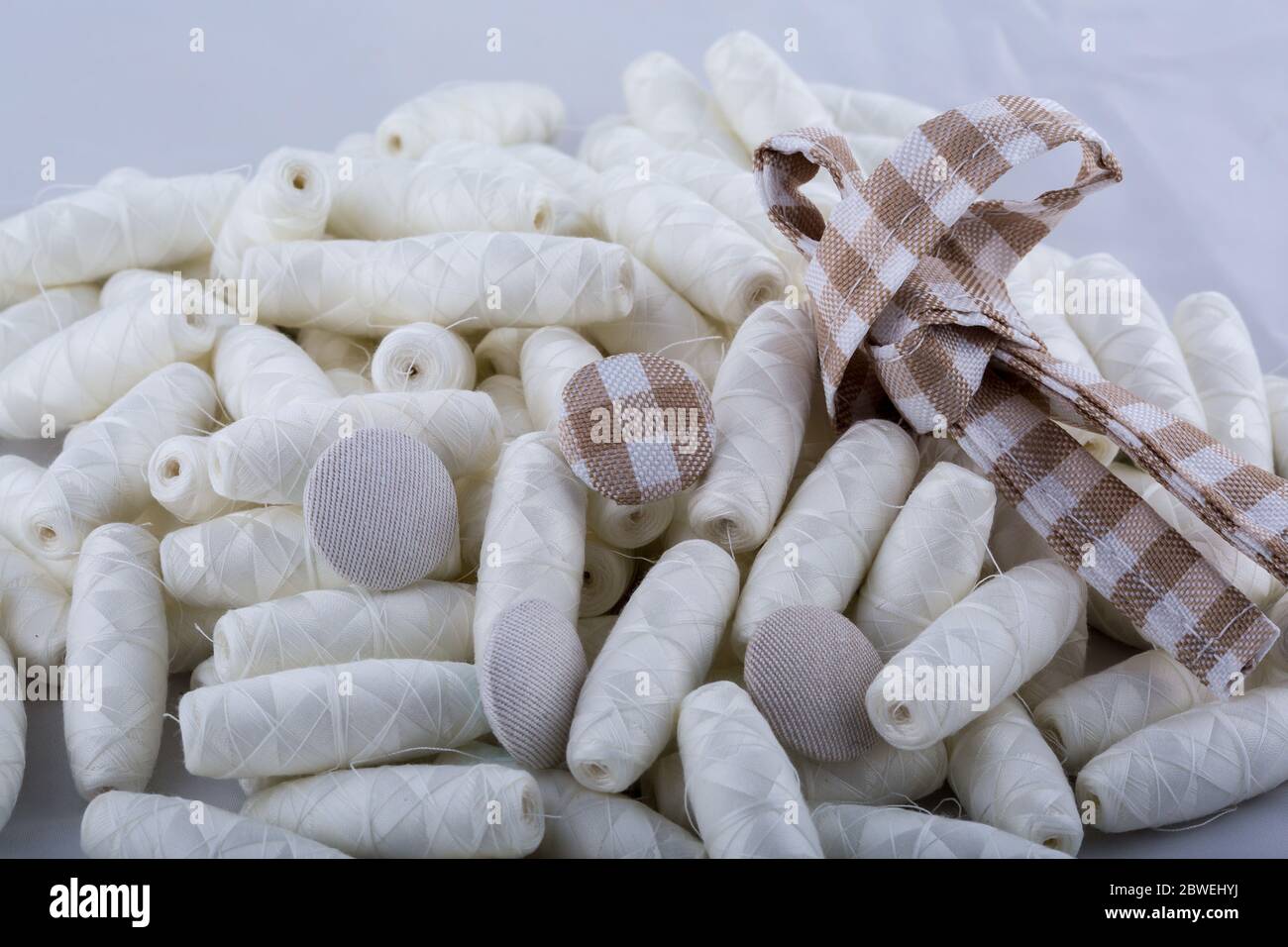A lot of cotton threads in bobbins scattered on the table. Materials for sewing and needlework. Stock Photo
