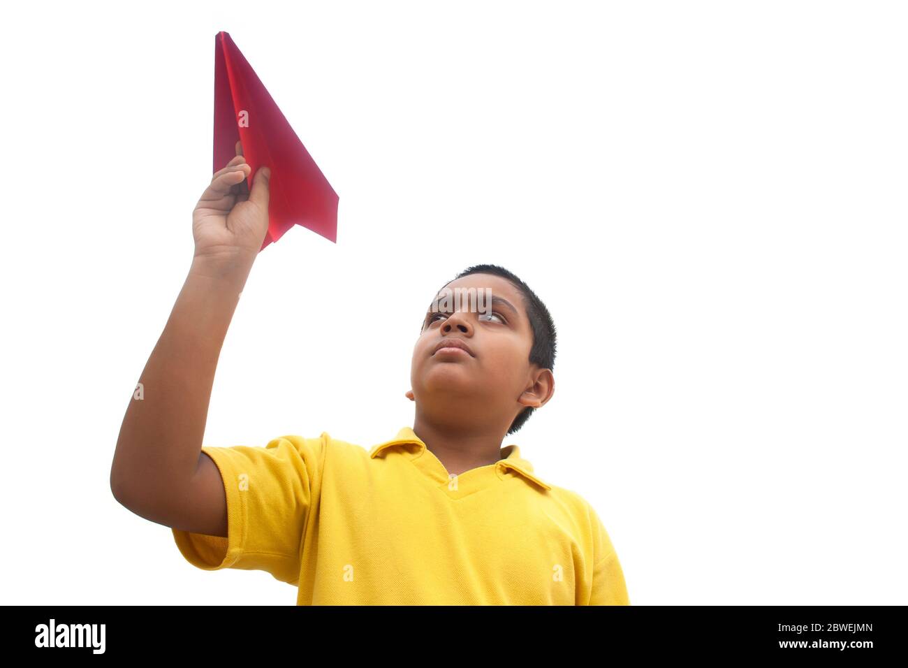 Boy playing with a paper plane and smiling Stock Photo