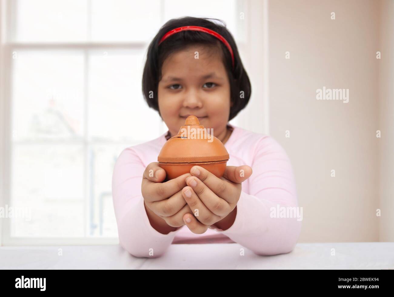 Young girl holding a piggy bank Stock Photo - Alamy