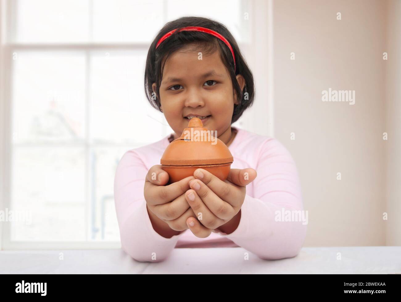 Young girl holding a piggy bank Stock Photo - Alamy