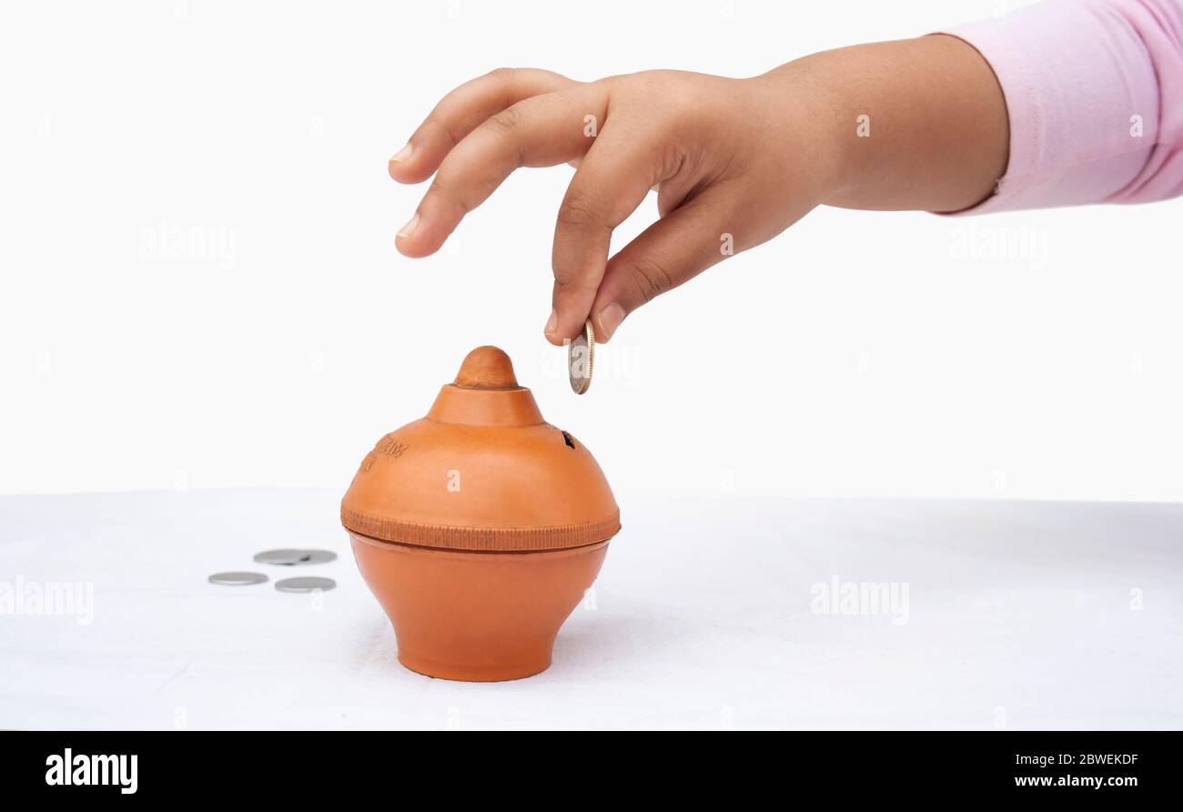 Little Girl putting coin into piggy bank, close-up Stock Photo - Alamy