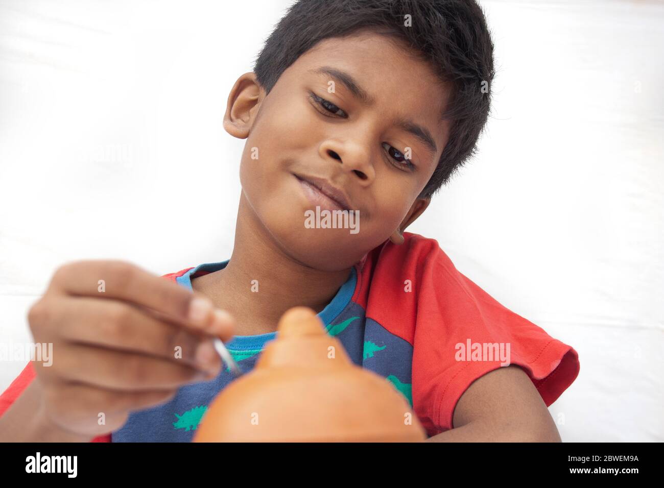 Close-up Boy putting coins into piggy bank Stock Photo - Alamy