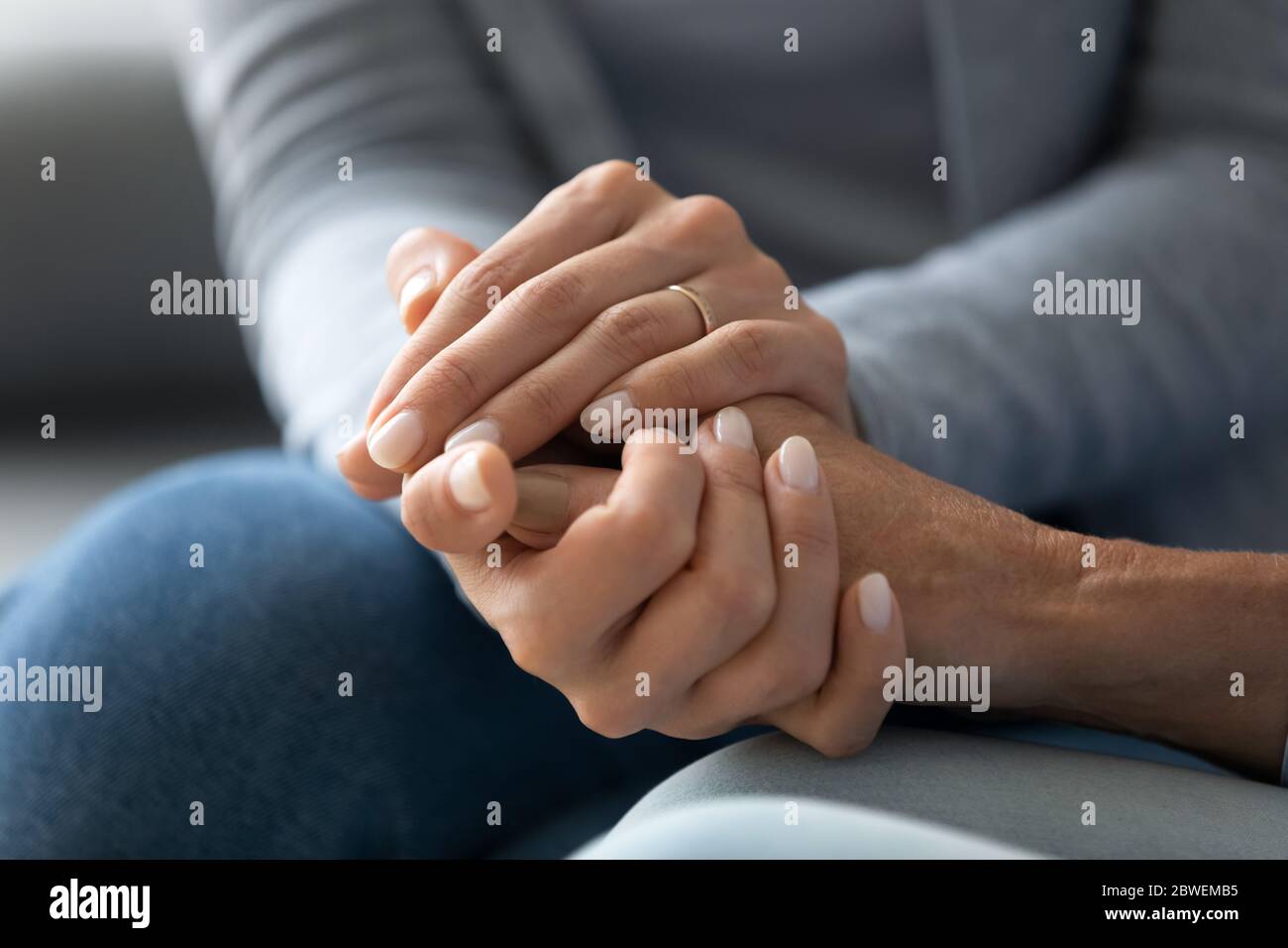 Closeup caring adult daughter holding mothers hand provides psychological support Stock Photo