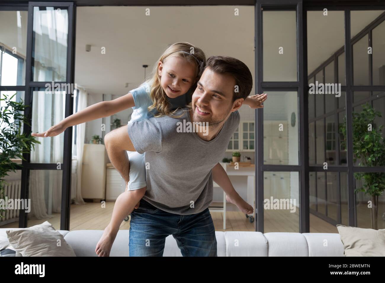 Happy young father play with little daughter at home Stock Photo