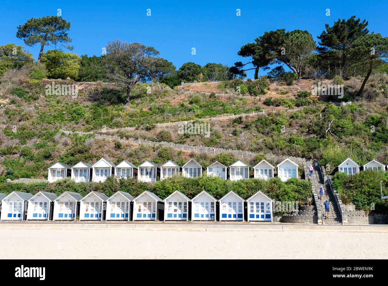 Branksome Chine Beach, Poole, Dorset, UK, 1st June 2020, Weather. More brilliant morning sunshine on the first day of meteorological summer following the sunniest spring on record in the UK. It’s Monday morning and the weekend crowds have gone. White beach huts under the cliffs are accessible via zig zag steps. Credit: Paul Biggins/Alamy Live News Stock Photo