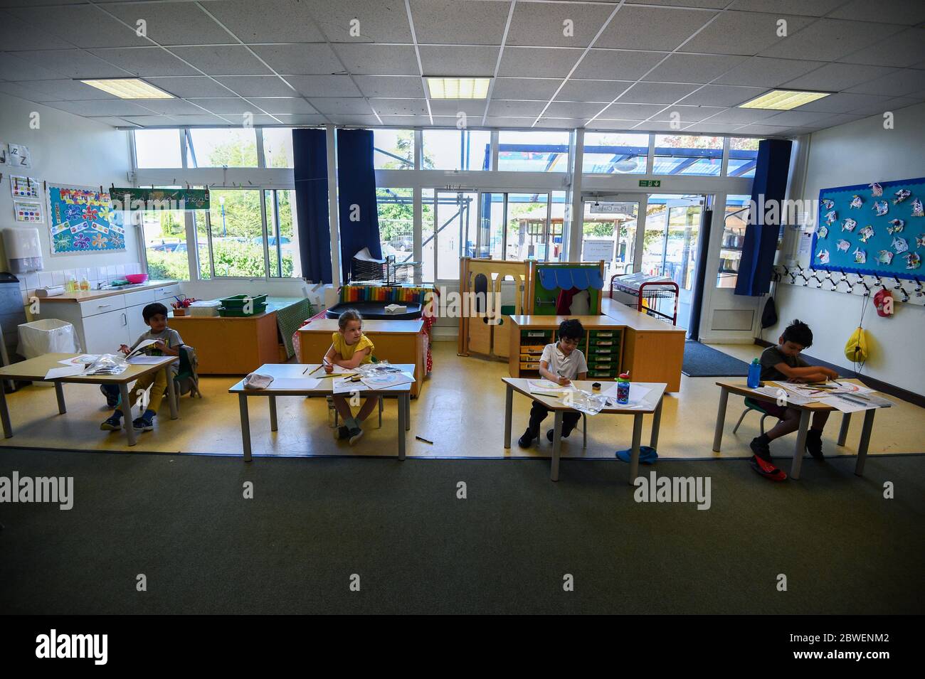 Pupils sit at separate desks at Hiltingbury Infant School in Chandler's Ford, Hampshire, as pupils in Reception, Year 1 and Year 6, begin to return to school as part of a wider easing of lockdown measures in England. Stock Photo