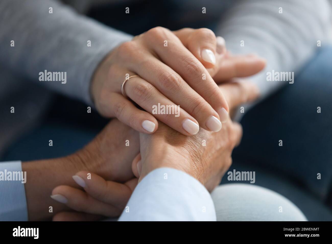 Adult daughter holding mothers hand close up image Stock Photo