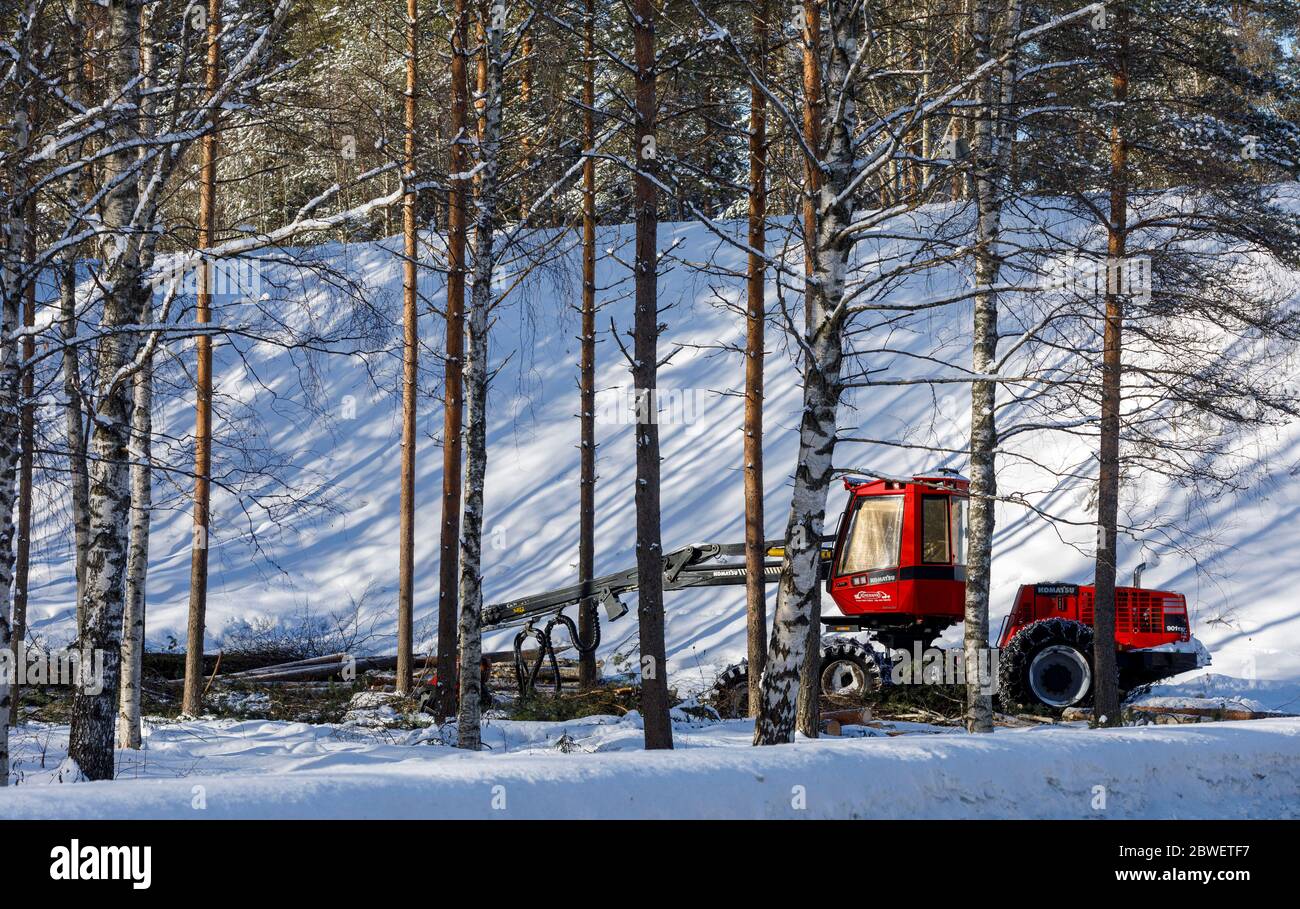 Red Komatsu 901 TX forest harvester thinning young forest at Winter , Finland Stock Photo