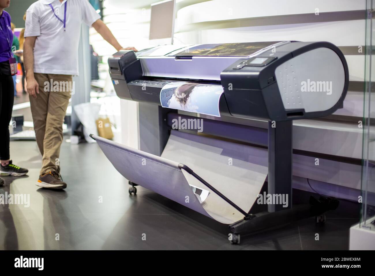 plotter prints a poster. standing next to people in blur. close-up, background in blur Stock Photo