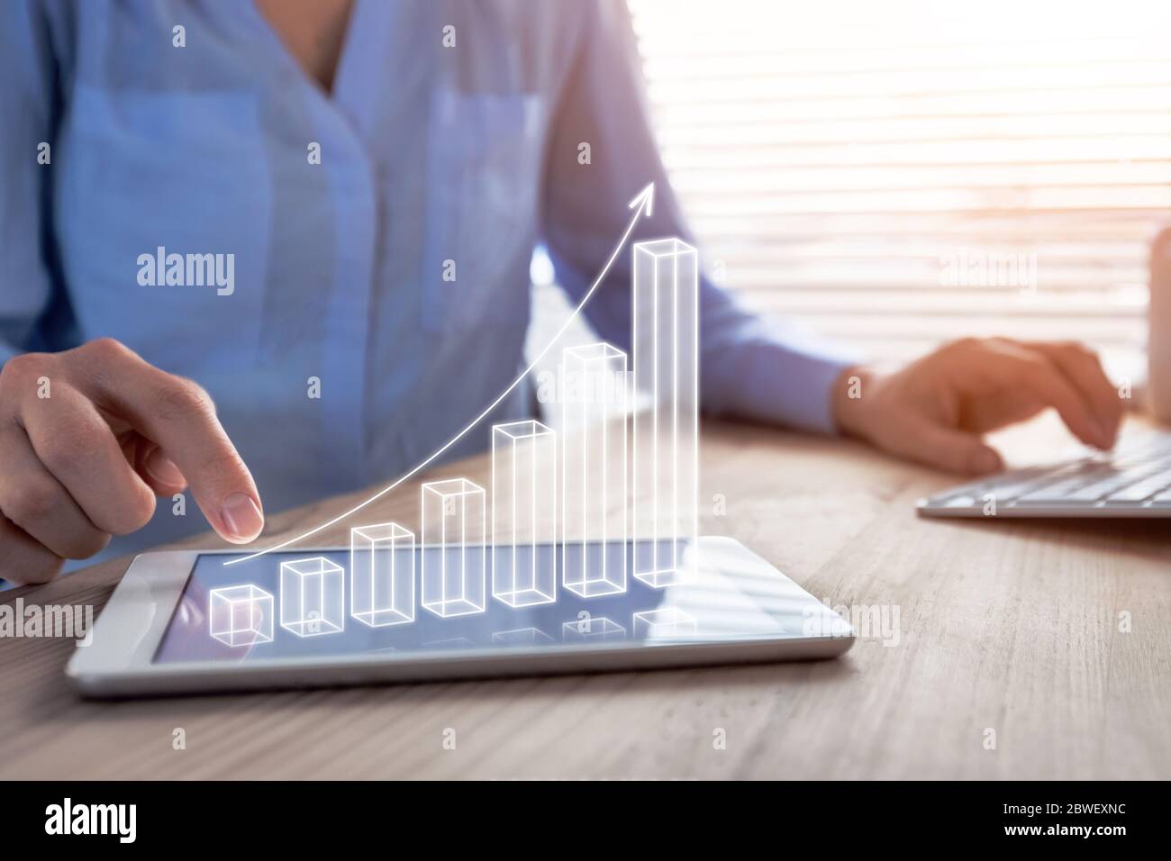 Business success and profit displayed by 3d growing bar chart, successful businesswoman working in bright office with computer and digital tablet, man Stock Photo