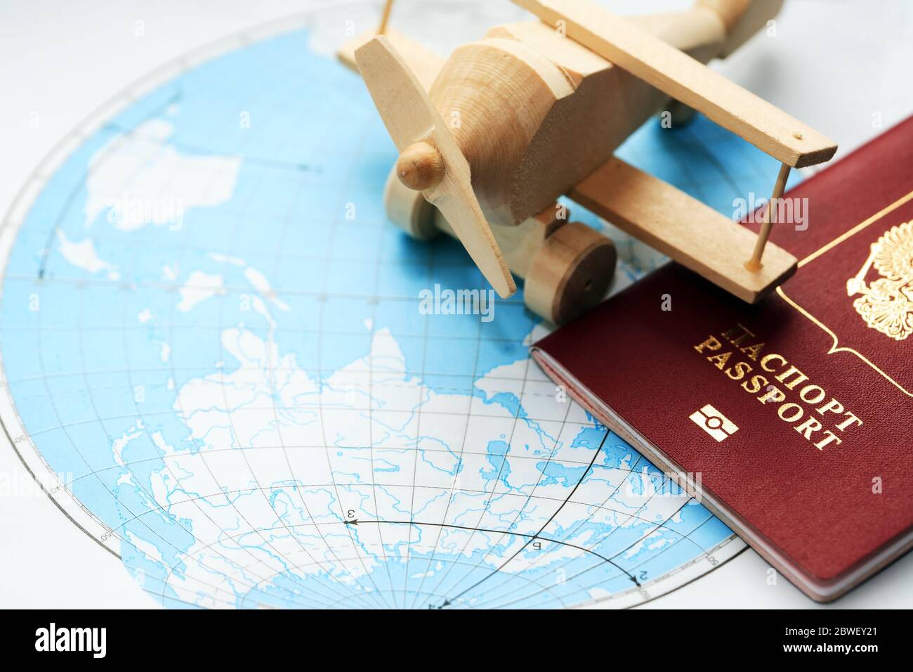 Travel concept. Small wooden airplane on map near passport Stock Photo