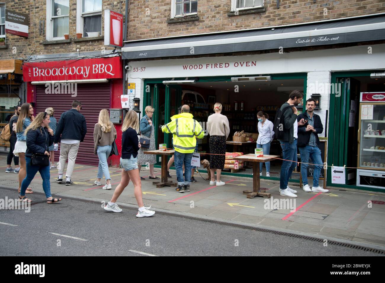 London May 2020 The Covid-19 pandemic. Broadway market. Socially distanced queue outside Bella Italia restaurant, now selling ingredients rather than Stock Photo