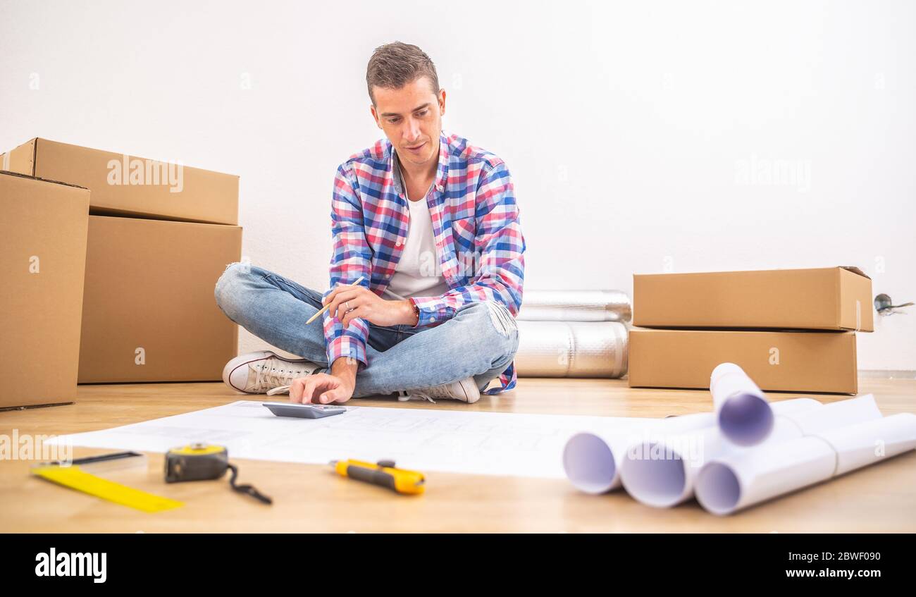 Unpacking 2012. After moving. мужик сидит на полу с обоями. фото бизнес переезда. переезд хаос.