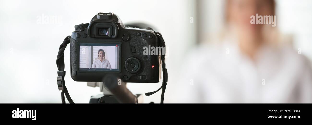 Closeup focus on professional dslr camera filming videovlog woman