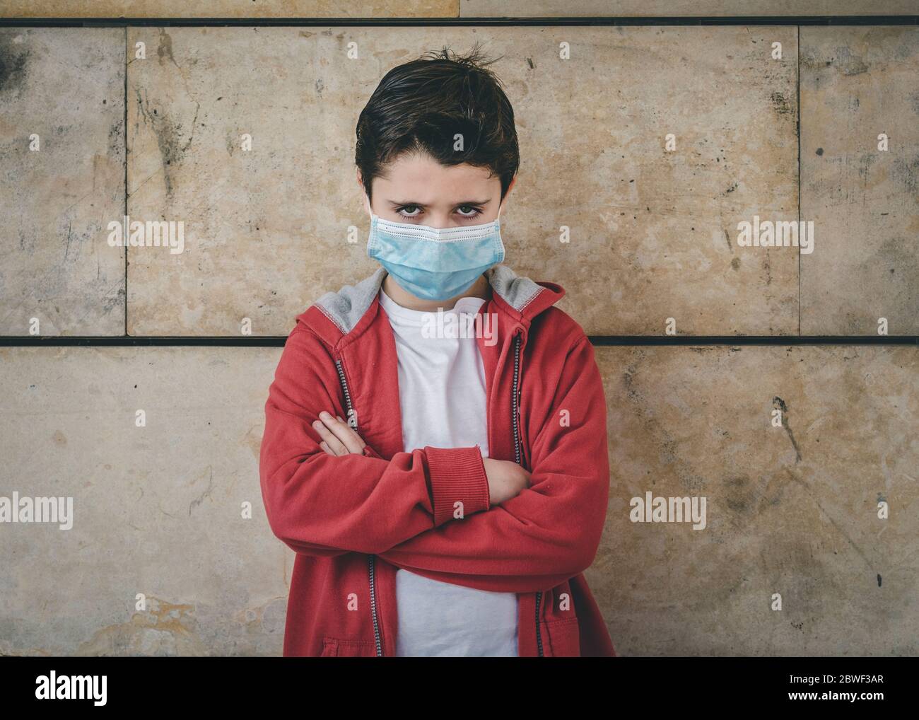 angry kid wearing medical mask outdoor Stock Photo