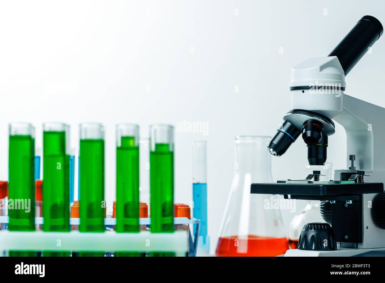 Laboratory microscope with colorful test tubes close up Stock Photo - Alamy