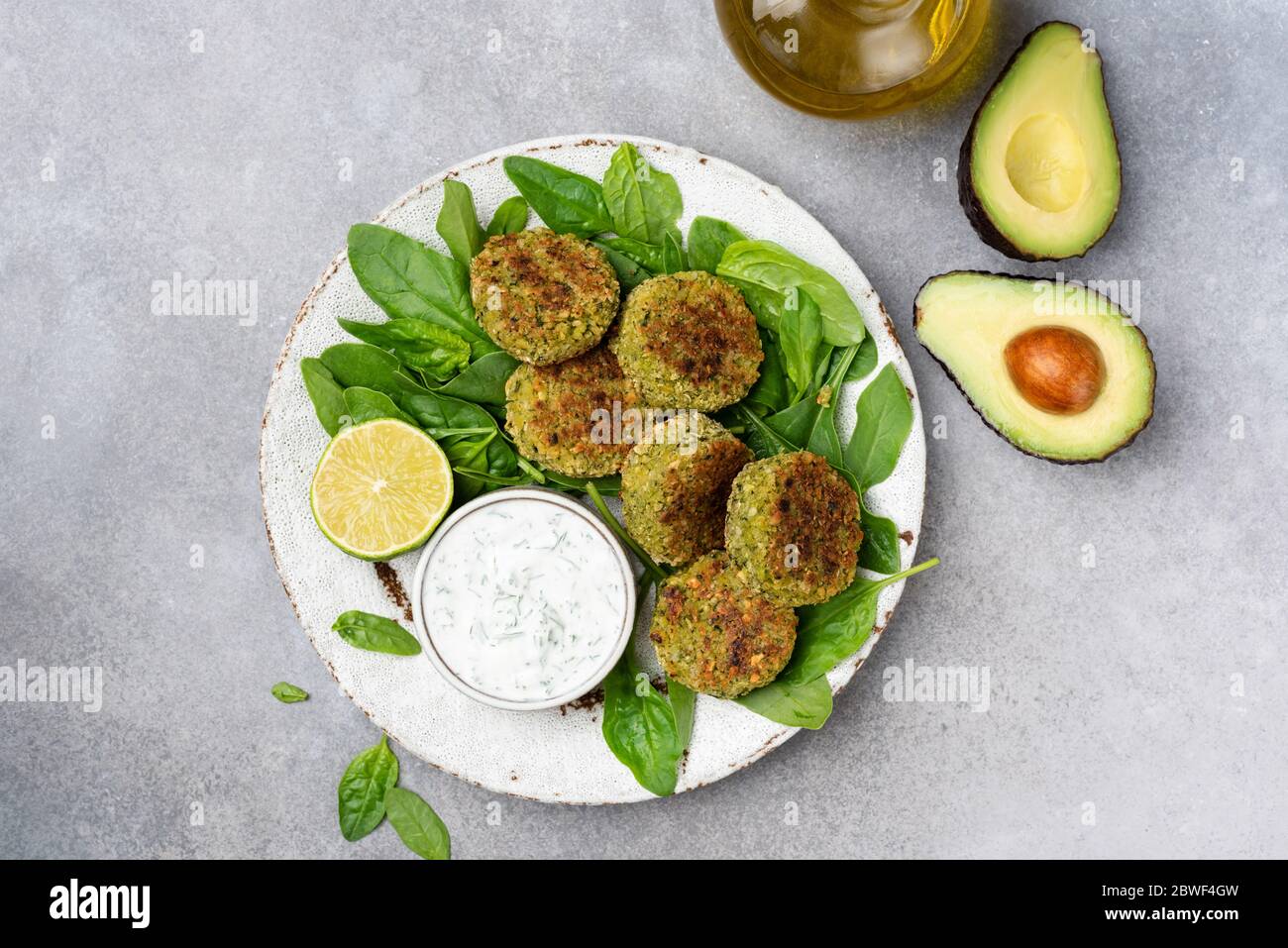 Falafel with yogurt sauce. Vegetarian spinach avocado chickpea fritters Falafel served with yogurt sauce on plate. Top view. Healthy vegetarian food Stock Photo