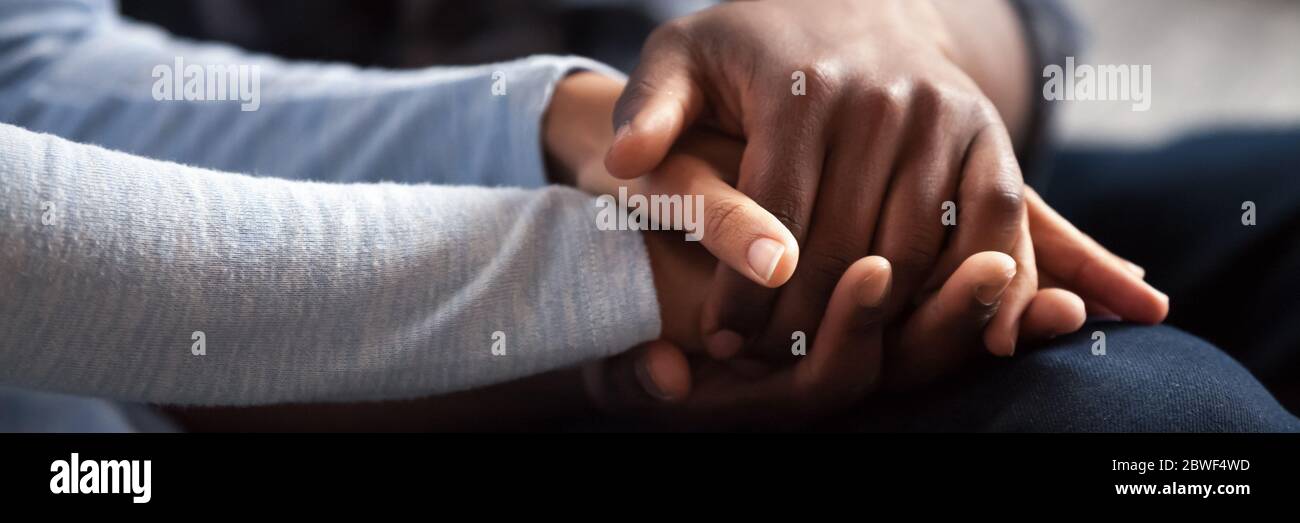 African couple holding hands, close up view horizontal image Stock Photo