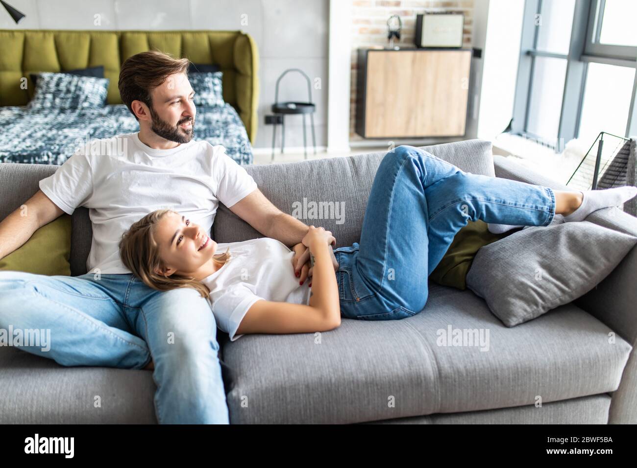 Cute couple relaxing on couch at home in the living room Stock Photo - Alamy