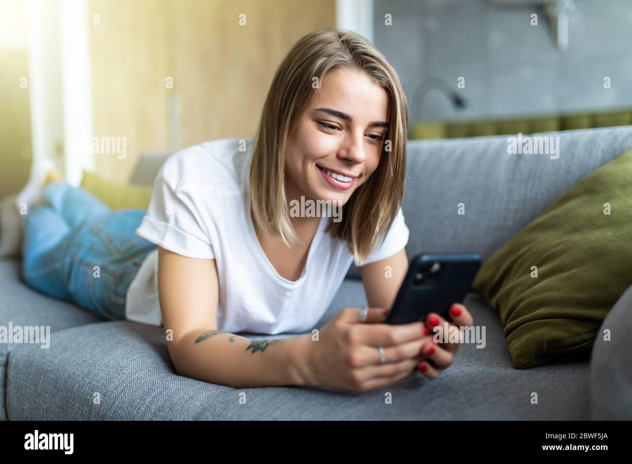 Selective focus of sexy girl lying on couch and taking off bra in front of  laptop with web camera Stock Photo by LightFieldStudios