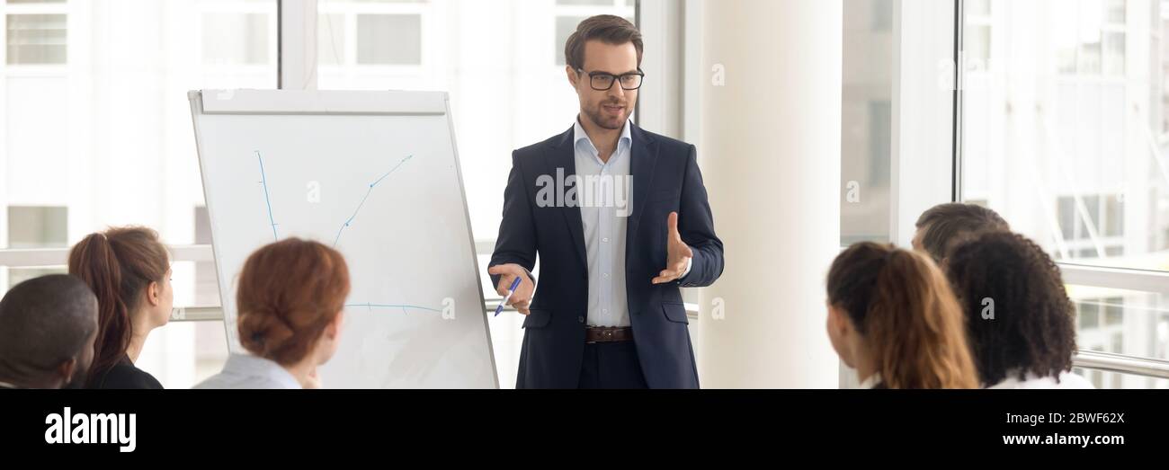 Trainer makes presentation during seminar using flipchart horizontal photo Stock Photo