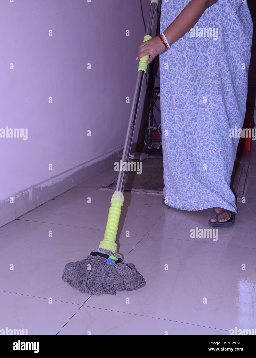 An Indian cleaner mopping or cleaning floor Stock Photo
