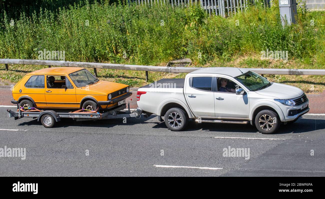 1981 orange Volkswagen Golf Driver; VW restoration project rare barn find, vehicle restoration project, restore old wreck, classic car on car trailer; UK Vehicular traffic, transport, saloon cars, automotive history on the 3 lane M6 motorway highway. Stock Photo