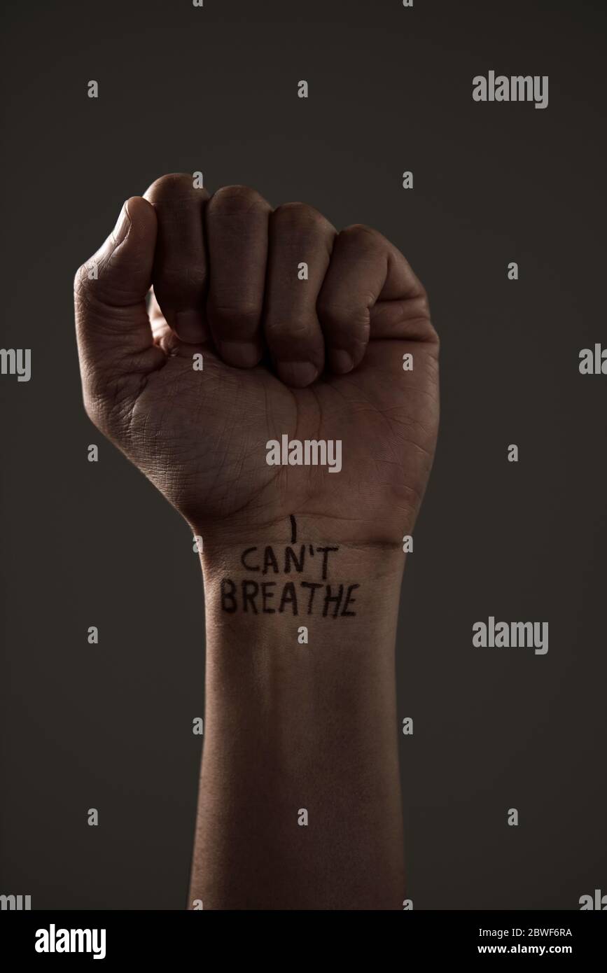 closeup of the raised fist of a man with the text I cant breathe in his wrist, as it is used as slogan in the George Floyd protests in response to pol Stock Photo