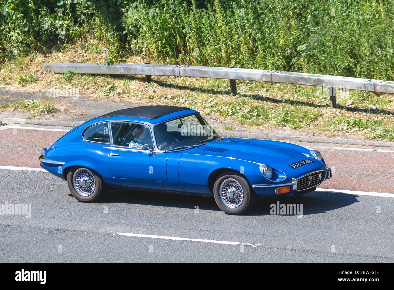1972 70s BLUE Jaguar 2+2 E Type; Vehicular traffic moving vehicles, cars driving vehicle on UK roads, motors, motoring on the M6 motorway highway Stock Photo