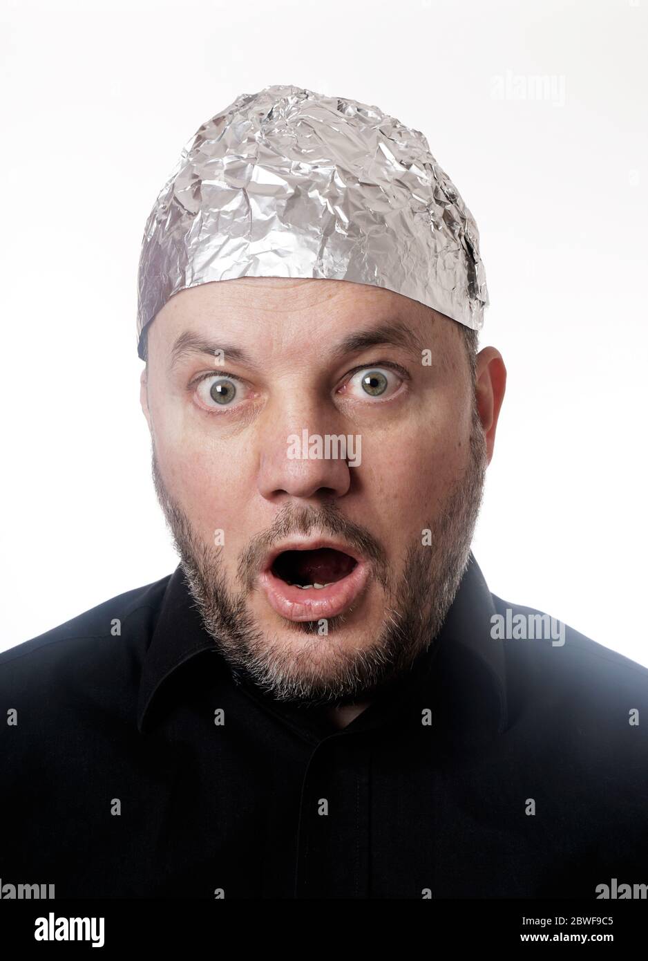 paranoid man wearing tin foil hat in shock - conspiracy theaory Stock Photo