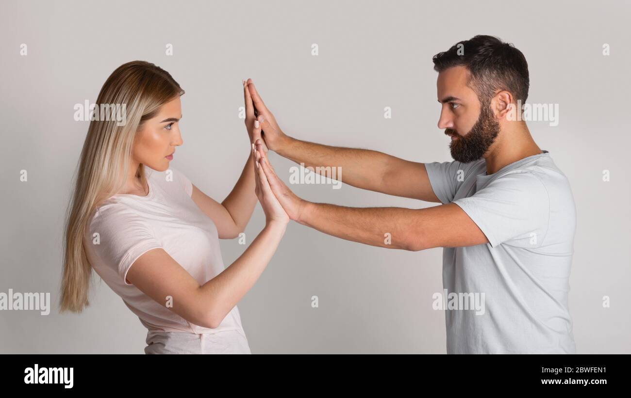 Confronting home repressor. Man presses woman with his hands, girl resists Stock Photo