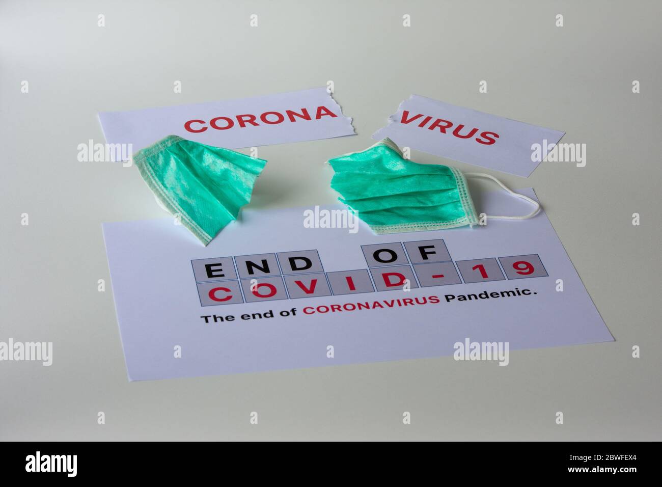 Tearing paper with the word 'Coronavirus' and cutting surgical mask. The end of the Coronavirus pandemic concept. Stock Photo