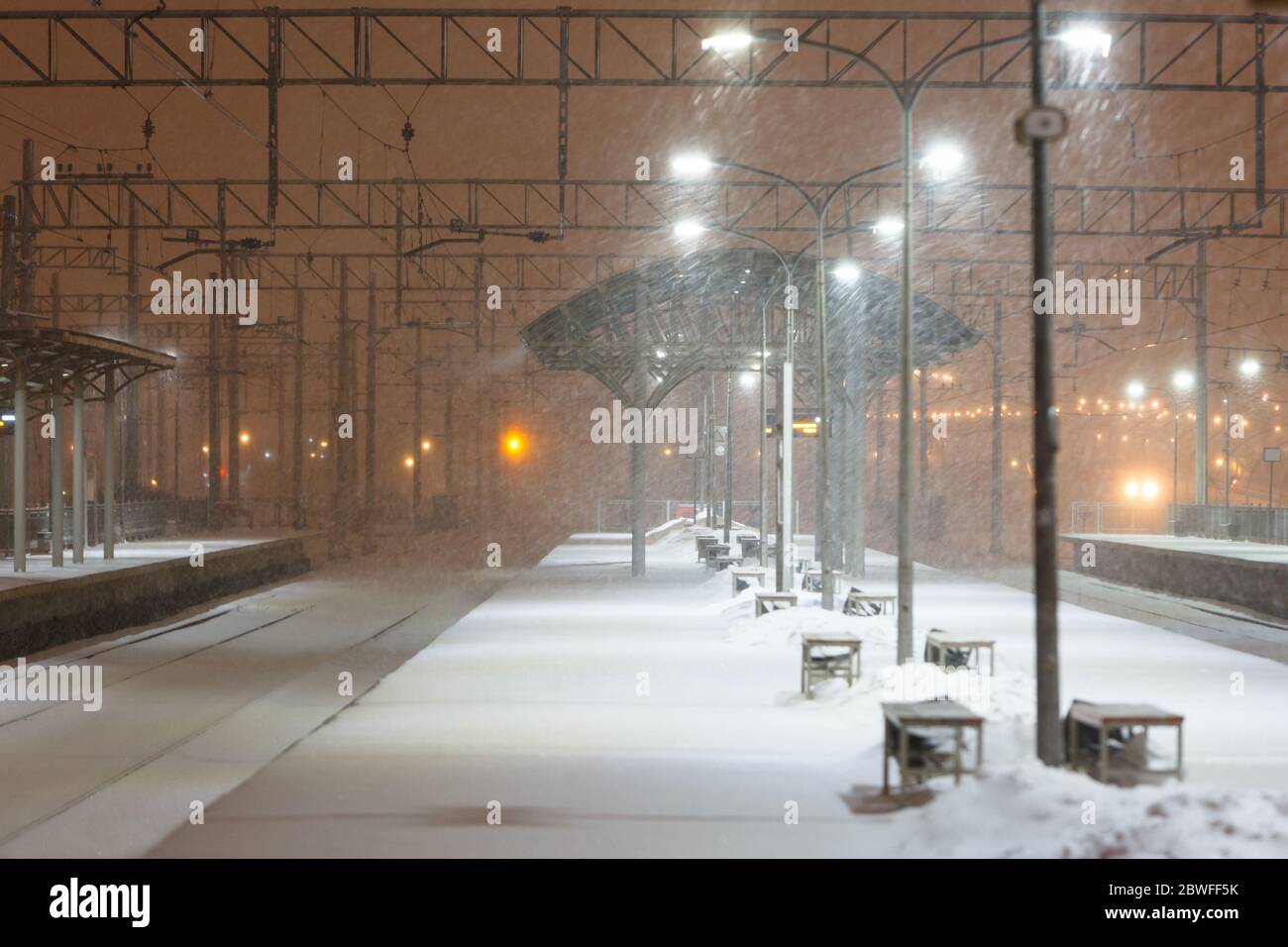 Empty railway platform without passengers in blizzard/heavy snowfall at night. Railway, bad weather Stock Photo