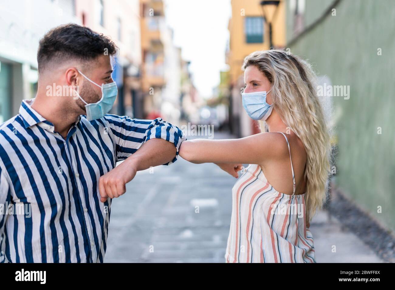Young people bump their elbows instead of greeting with a hug - Avoid the spread of coronavirus concept - Focus on elbows Stock Photo